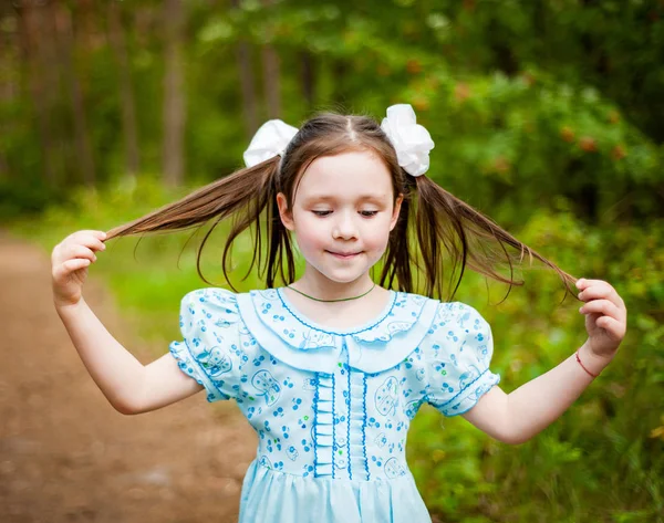 Χαριτωμένο κοριτσάκι που διασκεδάζει περπατώντας σε ένα ηλιόλουστο πάρκο — Φωτογραφία Αρχείου