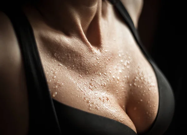 Woman in black bra, with wet skin on black background — Stock Photo, Image