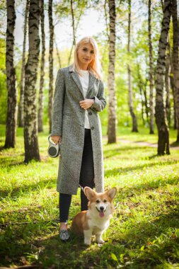 Genç bir kadın bir yaz parkı köpeğini yürüyor