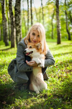 Genç bir kadın bir yaz parkı köpeğini yürüyor