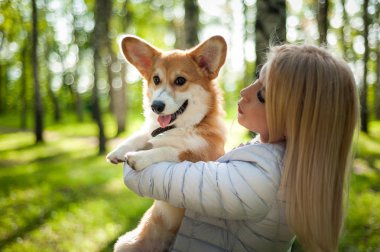 Genç bir kadın bir yaz parkı köpeğini yürüyor