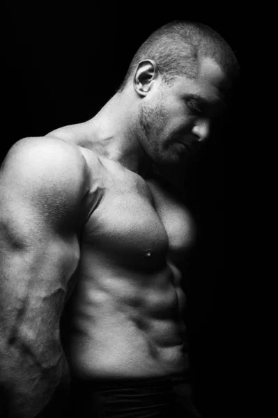 Siyah arka planda duran sporcu, spor yapıyor.