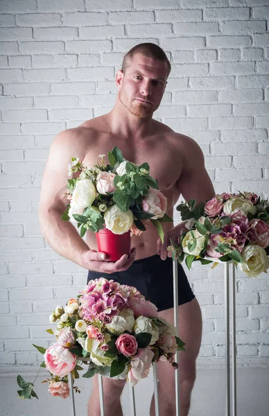 セクシーな男性アスリートとともに花束の花上の白い背景 — ストック写真