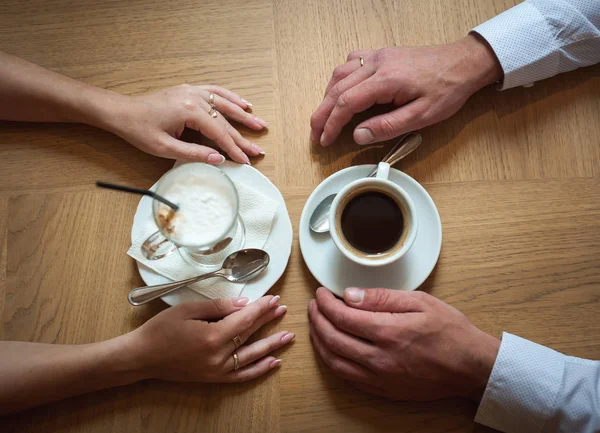 Couple in love holding hands in a cafe. Focus on hands — Stock Photo, Image