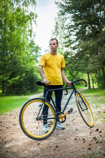 젊은이는 공원에서 자전거를 멈추었다 속에서 순니의 아침을 즐긴다 — 스톡 사진