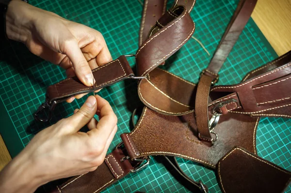 Production of leather products, close up. The view from the side. The master makes a leather product to order.