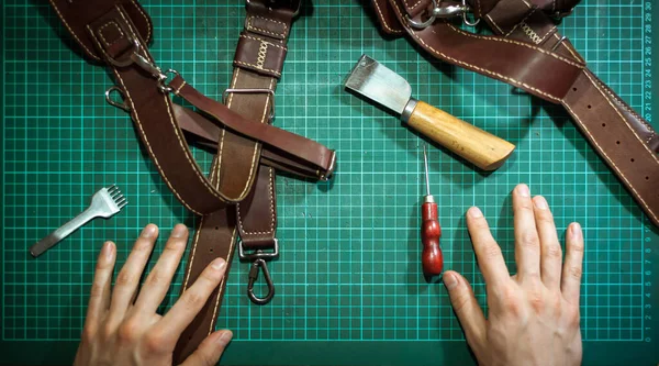 Production of leather products, close up. The view from the top. The master makes a leather product to order.