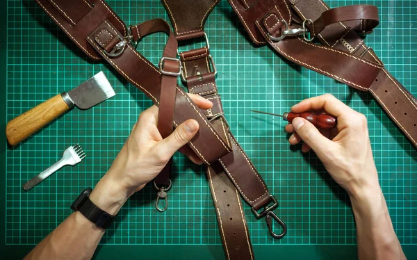 Production of leather products, close up. The view from the top. The master makes a leather product to order.