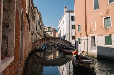 Venedik, İtalya - 13 Ağustos 2016: Bir adam Venedik, İtalya kanalında bir tekneye biniyor.