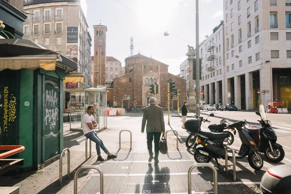 Milan, İtalya - 11 Ağustos 2016: Milano Piazza San Babila 'daki insanlar. Sabah, insanlar işe gidiyor, İtalya 'nın Milano kentindeki San Babila kilisesinin yanından geçiyorlar..