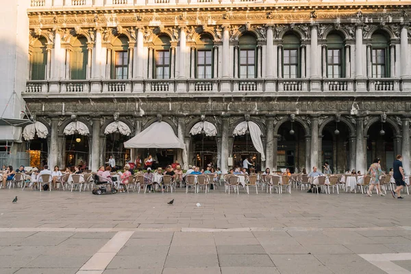 Venedik, İtalya - 13 Ağustos 2016: İnsanlar İtalya 'nın Venedik kentindeki Piazza San Marco' daki restoranın masalarında oturuyorlar.