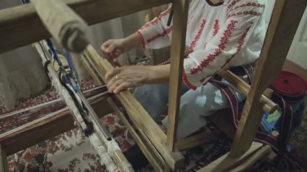 古い木製の織り機の伝統的な帯を織っている人の織工の手持ちミディアム ショット — ストック動画