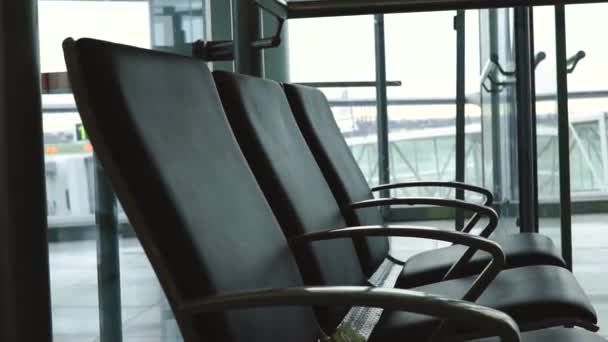 Sitze am Flughafen mit Flugzeug und Autos im Rücken — Stockvideo