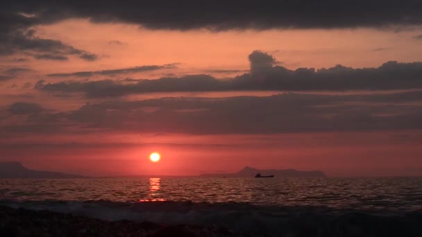 Закат с видом на горы и лодку на берегу моря — стоковое видео