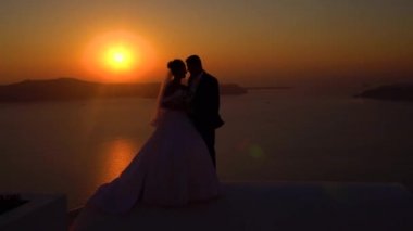 Santorini, Yunanistan günbatımı rooftops üzerinde genç düğün çifti