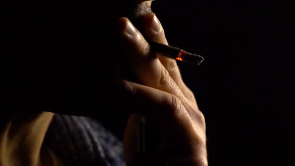 Cigarrillo, hombre con barba, malos hábitos, sobre fondo negro, silueta cámara lenta — Vídeos de Stock