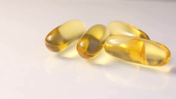 Afbeelding van enkele vitamine E capsules geïsoleerd op witte achtergrond. — Stockvideo