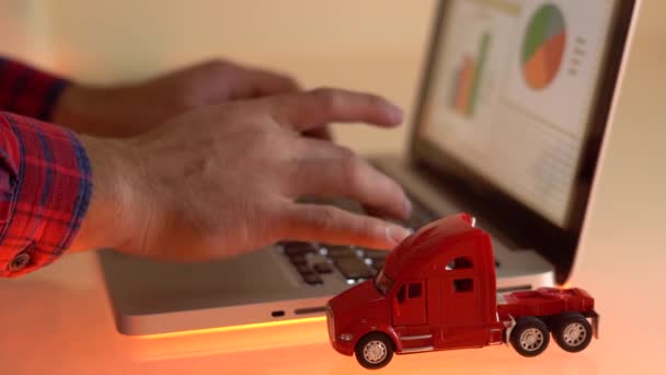 Primo piano di un piccolo camion giocattolo rosso sulla tastiera del computer portatile — Video Stock
