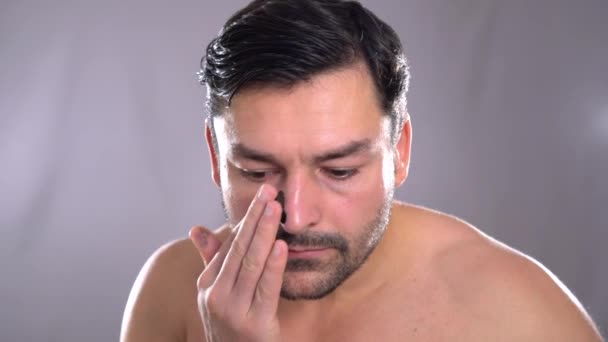 Homem usa creme facial Jovem bonito homem usando creme isolado no branco — Vídeo de Stock