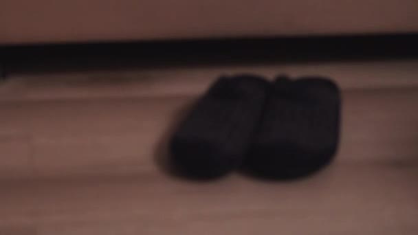 腿从床上下来, 从床上下来, 把拖鞋放在他的脚 — 图库视频影像