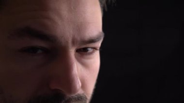 Korkunç adam düşük anahtar portresi ile kötü gözleri yakın çekim Genç bir adam portresi