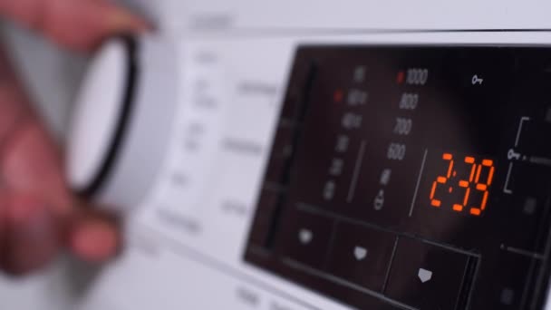 Крупный план женской ручной токарной кнопки стиральной машины — стоковое видео
