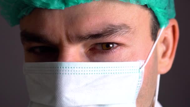 Закрыть портрет хирурга или врача в маске и наушниках, готовых к операции в больнице или клинике — стоковое видео