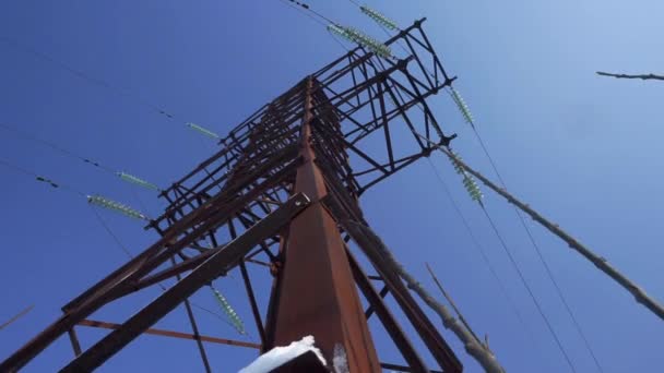 Upward view diagonally to the power line and pylon against a blue sky with clouds — Stock Video