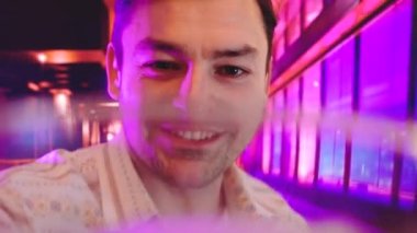 Adam bira içme, modern iç Bar veya Pub gibi arka planda ile serin Neon ışıkları mor, mavi ve pembe çift tonlu degradeleri