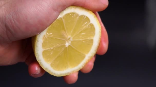 Slow Motion squeeze sap van de citroen close-up. Hand Squeeze verse citroen. Citroen sap afvoerleidingen van de Pulp en druppels. — Stockvideo