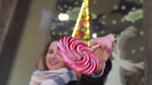 Fille drôle manger sucette sur fond de pois roses . — Video