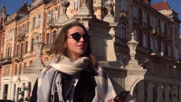 Retrato de una hermosa joven turista de vacaciones visitando Praga usando su teléfono inteligente para tomar una foto selfie de sí misma durante un día soleado. Tecnología y estilo de vida . — Vídeo de stock