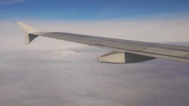 Uçak uçuşu. Gün batımı gökyüzü ile bulutların üzerinde uçan bir uçağın kanadı. Uçağın penceresinden bak. Uçak, uçak. Hava yoluyla seyahat etmek.