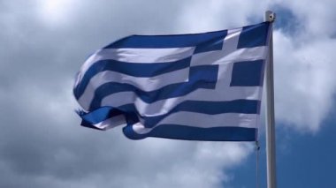 Yunan bayrağı açık mavi gökyüzüne karşı rüzgarsal sallayarak. Parlak Güneş Işığında Yunan Bayrağı