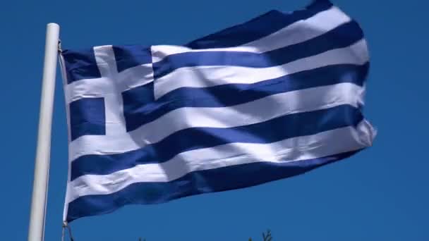 Bandera griega ondeando en viento contra el cielo azul claro. Bandera griega en la luz del sol brillante — Vídeos de Stock