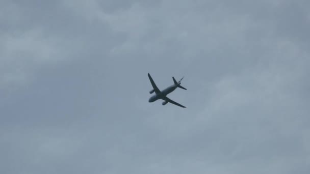 Samolot leci nad głową na wyjeździe przez błękitne niebo. Wchodzi i pozostawia strzał. — Wideo stockowe
