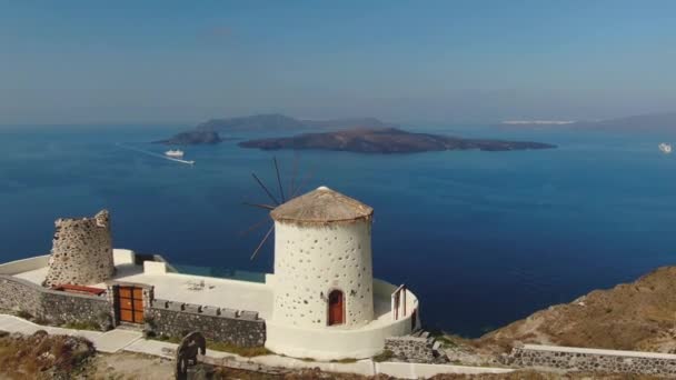 4k πλάνα που δείχνουν όμορφη θέα της Οίας και άλλων περιοχών, εκκλησίες, Αιγαίο Πέλαγος, μπλε θόλος, ανεμόμυλος στο νησί της Σαντορίνης στην Ελλάδα — Αρχείο Βίντεο