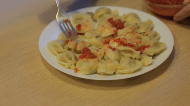 Man eating dumplings with beef and tomato sauce at home in the kitchen — Stock Footage Man eating dumplings with beef and tomato sauce at home in the kitchen Video Clip