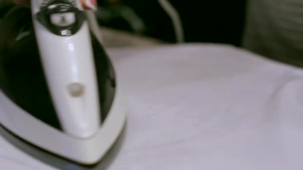 A housewife ironing white T-shirt with electric iron — Stock Footage A housewife ironing white T-shirt with electric iron Stock Footage