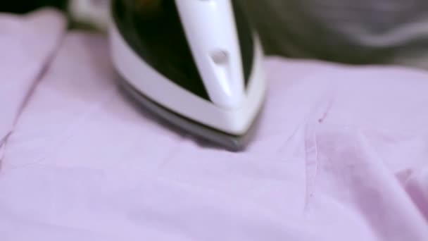A housewife ironing white T-shirt with electric iron — Stock Footage A housewife ironing white T-shirt with electric iron Royalty Free Stock Footage