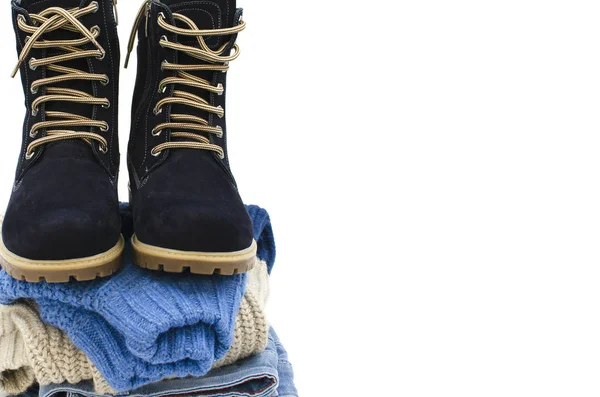 A pile of clothes with boots are on a white background