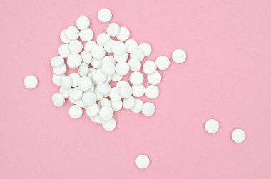 Pembe bir arka plan üzerinde beyaz haplar