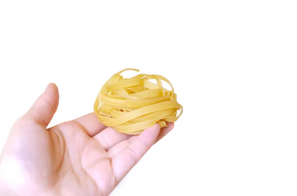 Fettuccine Sin Cocer Mano Femenina Sobre Fondo Blanco — Foto de Stock