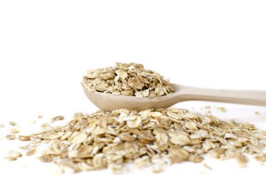 Beyaz arka planda müsli olan tahta kaşık.