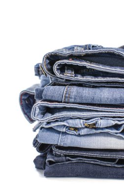 Beyaz arka plan denim mavi kot yığını. Giysi, moda, hayır severlik