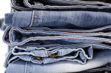 Beyaz arka plan denim mavi kot yığını. Giysi, moda, hayır severlik