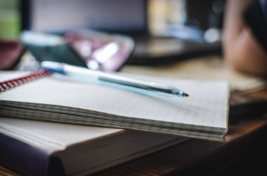 Kitap, dizüstü bilgisayar, gözlük, masa üzerinde kalem ile dizüstü bilgisayar