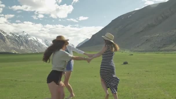 Trendige Hipster-Mädchen, die Spaß im Freien haben. drei niedliche Frauen wirbeln auf grünem Gras. beste Freunde. — Stockvideo