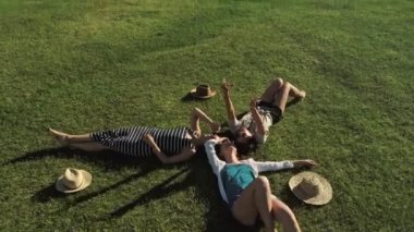 Trendy Hipster kızlar çim üzerinde rahatlatıcı. Yaz yaşam tarzı portre üzerinde çim döşeme üç hipster kadınların zevk güzel bir gün. En iyi arkadaşlar kızlar eğleniyor, sevinç.