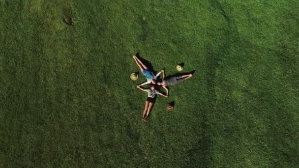 Trendy Hipster Girls ontspannen op het gras. Zomer levensstijl portret van drie vrouwen van de hipster opleggen van het gras genieten van de mooie dag. Beste vrienden meisjes plezier, vreugde. — Stockvideo